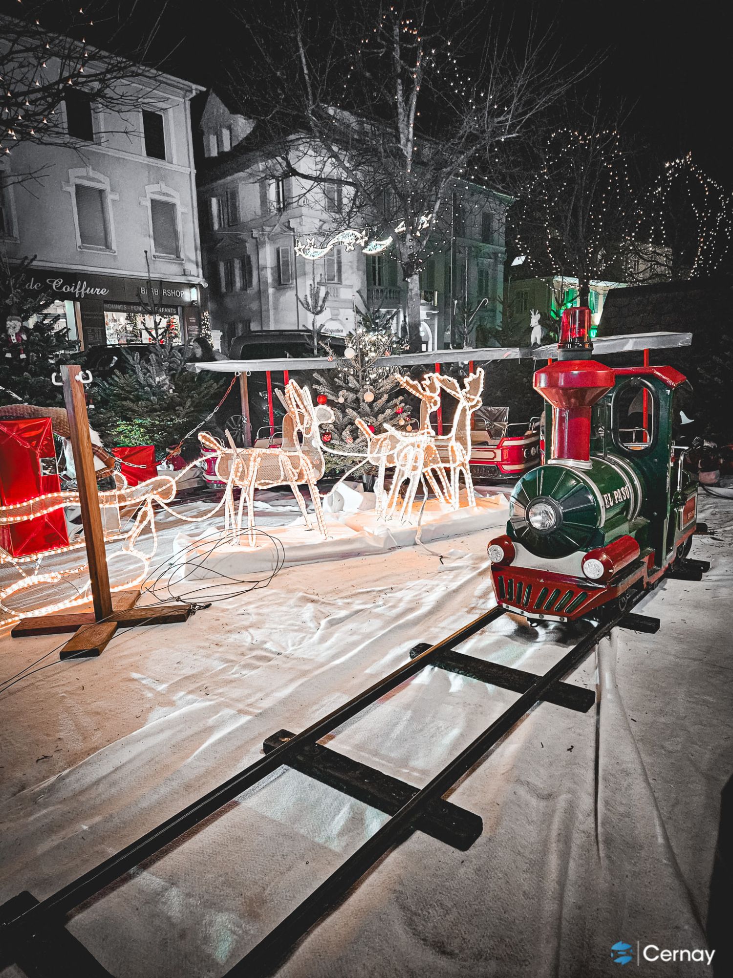 Noël à Cernay On y voit un petit train manège pour les enfants dans un décor féérique de Noël