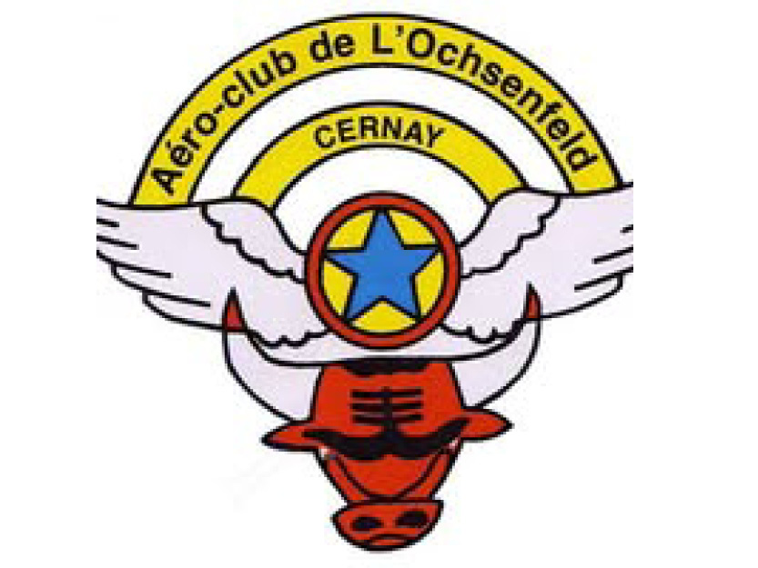 On y voit la tête d'un taureau rouge avec des ailes au dessus des cornes avec une un rond rouge  au centre une étoile bleu et de 2 demi cercles jaunes avec  noté aéroclub de l'ochsenfeld Cernay