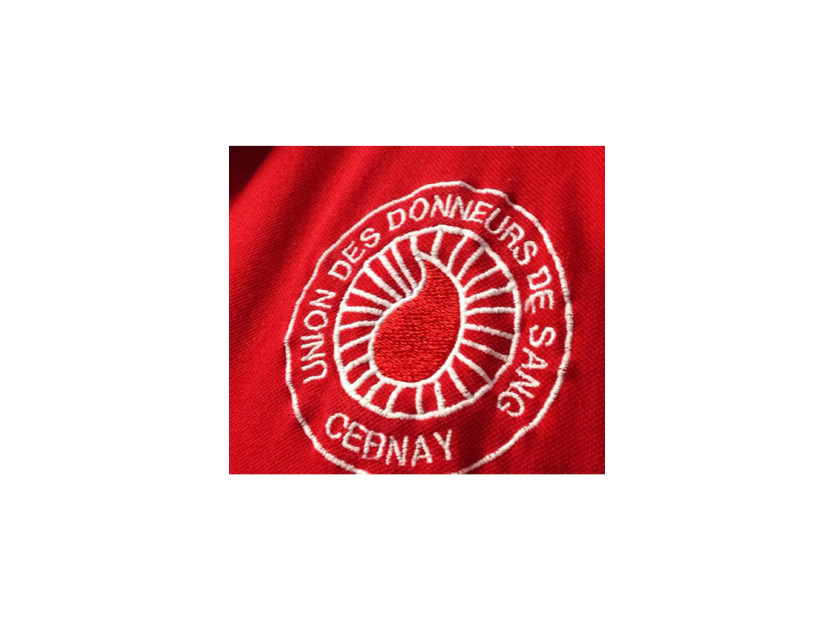 On voit une goutte de sang dans un rond blanc sur un tee-shirt rouge