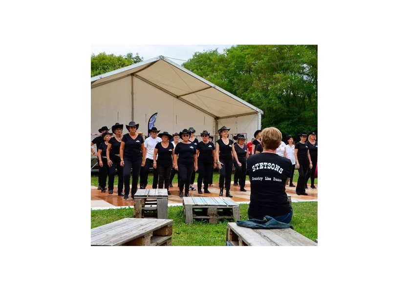 On y voit des danseurs et danseuses en ligne et sur leurs tee-shirts ont y voit le logo de stetsons
